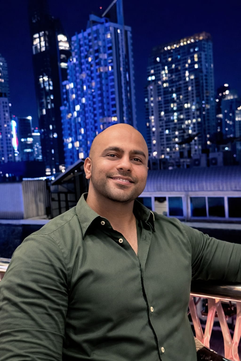 Saurabh with the city skyline lit up at night